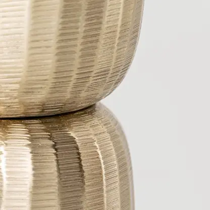 Closeup of gold metal decorative stand showing detailed textured surface and refined shape ideal for modern elegant interior styling.