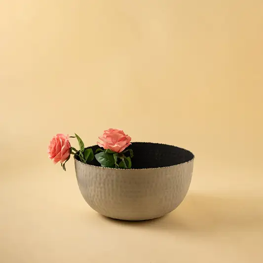 Modern hammered metal bowl in soft grey tone displayed in a warm minimal setting adding subtle texture to decor.
