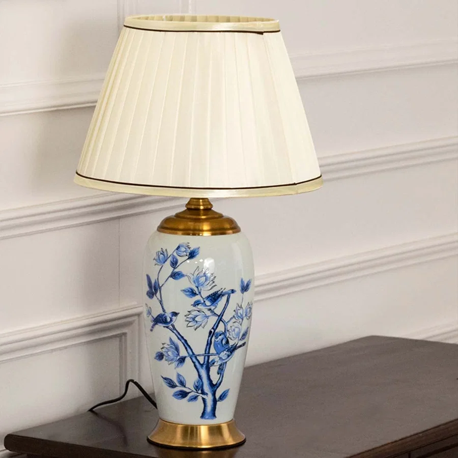 Blue and white ceramic table lamp with a cream pleated shade maintaining decorative charm even when unlit perfect for luxury home decor.
