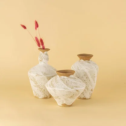 Set of handcrafted white and brown ceramic vases displayed together creating warm organic and artisanal decor styling.
