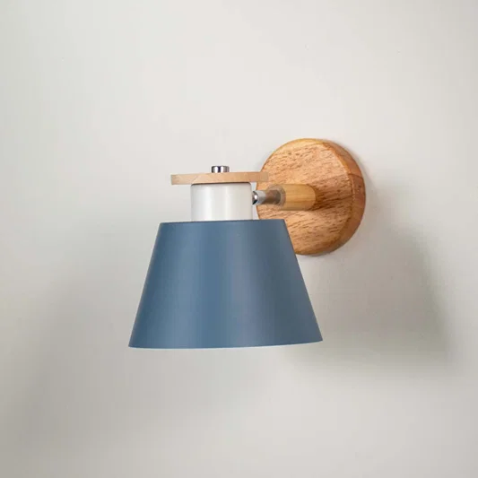 Elegant blue metal shade wall light with wooden mount fixed on soft white wall background perfect for modern interior decor lighting.