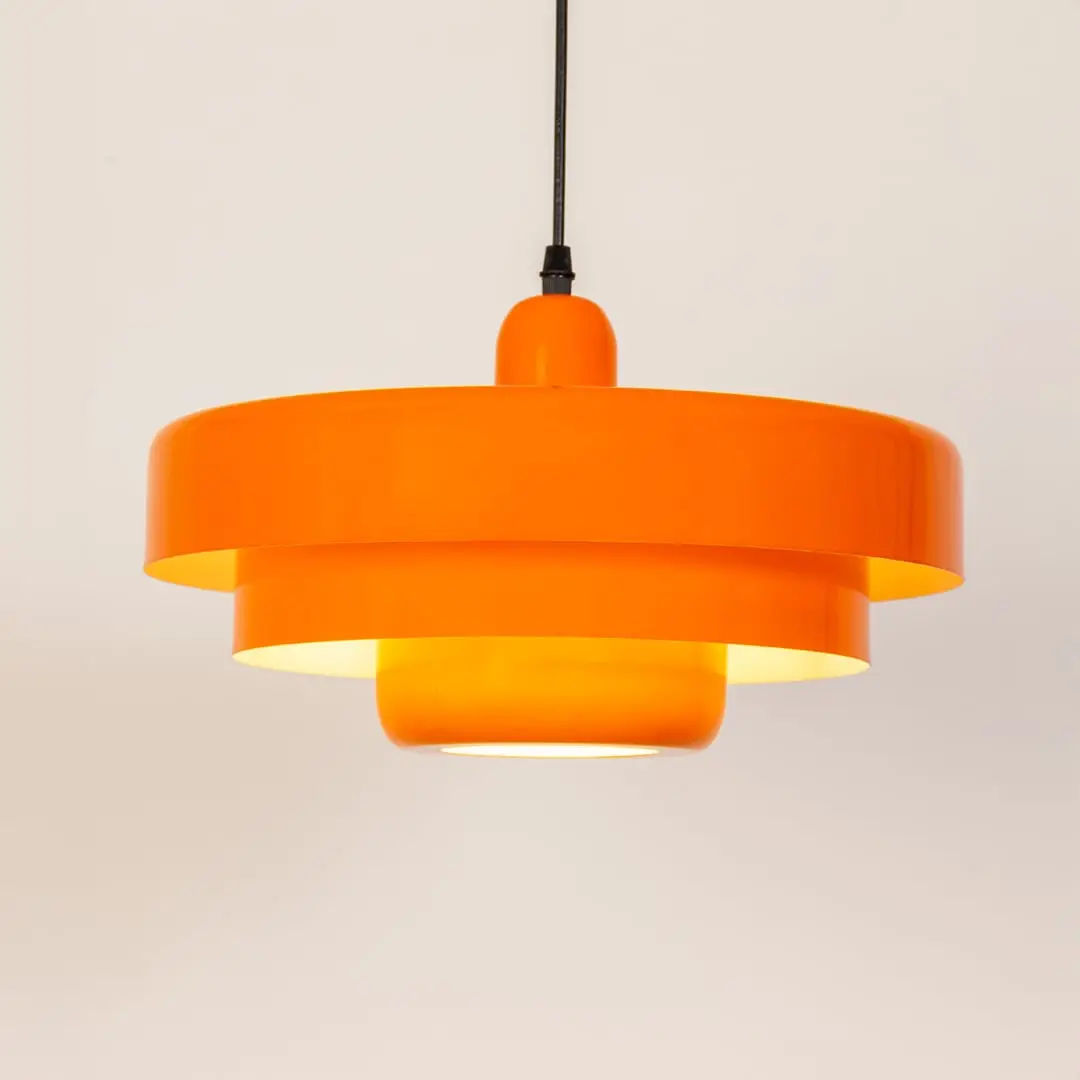 Orange metal pendant light with layered shade design for kitchen island dining room and modern ceiling lighting.