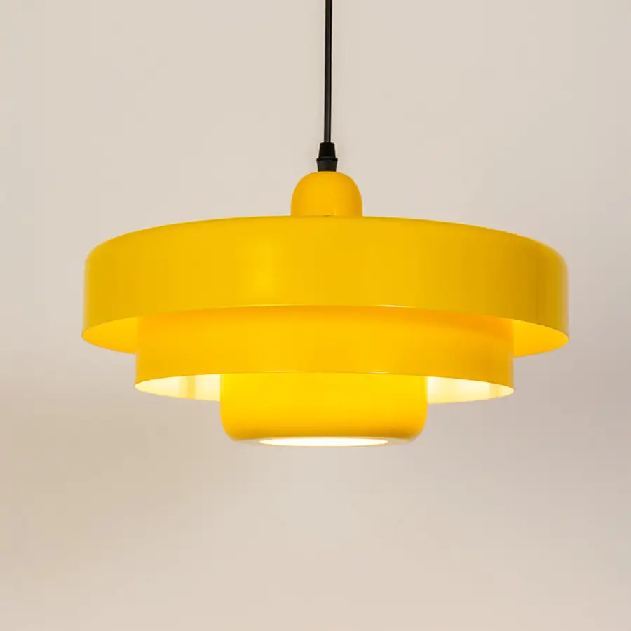 Modern pendant light in yellow metal finish with layered shade for kitchen or dining decor lighting white background.