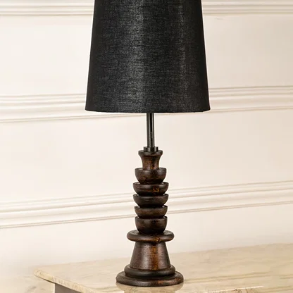 Turned wood lamp base with rich dark finish and bronze accents showcasing classic craftsmanship and decorative appeal.