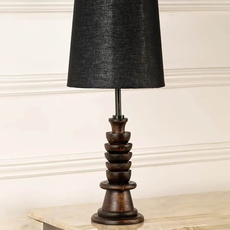 Turned wood lamp base with rich dark finish and bronze accents showcasing classic craftsmanship and decorative appeal.
