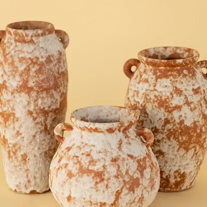 Collection of handcrafted terracotta ceramic vases in rustic orange white textured finish for tabletop decoration.