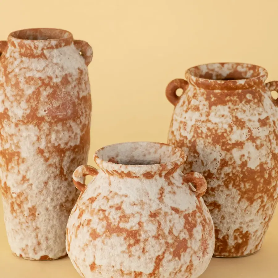 Collection of handcrafted terracotta ceramic vases in rustic orange white textured finish for tabletop decoration.