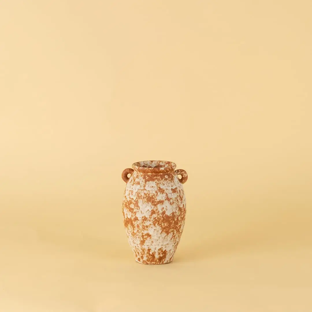 Handcrafted terracotta ceramic vase with dual handles in rustic orange white textured finish for modern home decoration.