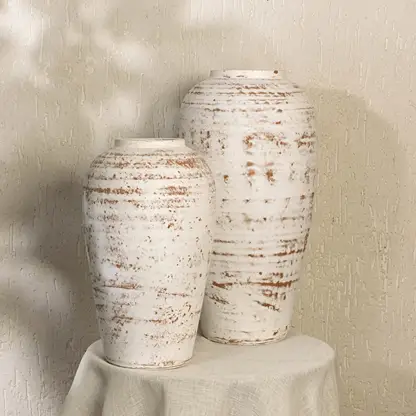 White rustic textured decorative vase styled in a warm modern room adding elegant artistic decor to living rooms hallways and contemporary interiors.