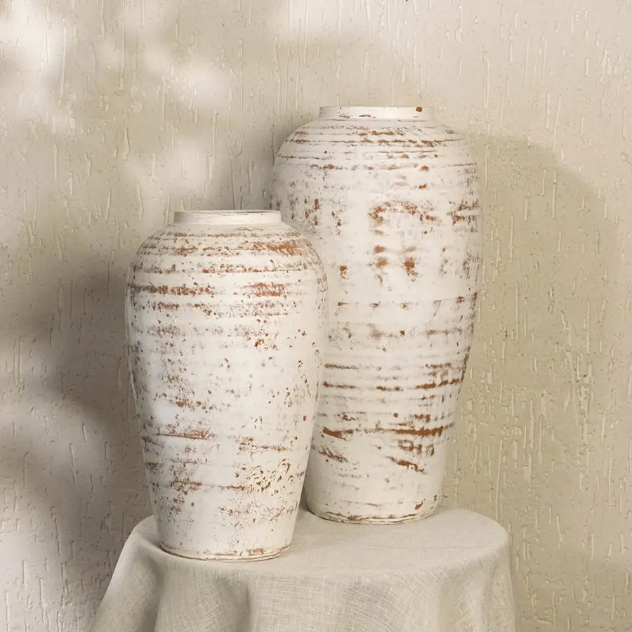 White rustic textured decorative vase styled in a warm modern room adding elegant artistic decor to living rooms hallways and contemporary interiors.