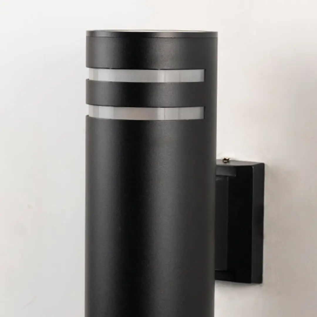 Closeup of tall black cylindrical wall light with smooth matte surface and refined dual silver ring detailing.