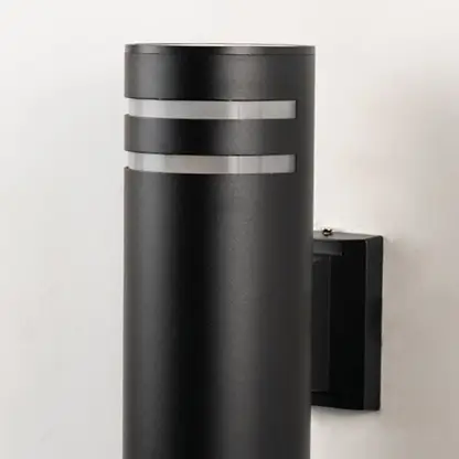 Closeup of tall black cylindrical wall light with smooth matte surface and refined dual silver ring detailing.