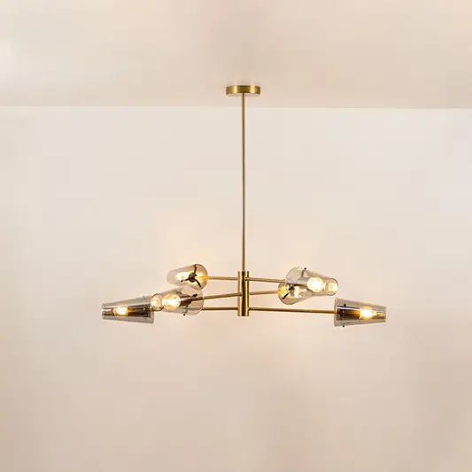 Clear glass chandelier with gold metal frame and illuminated bulbs creating warm contemporary ceiling lighting indoors.