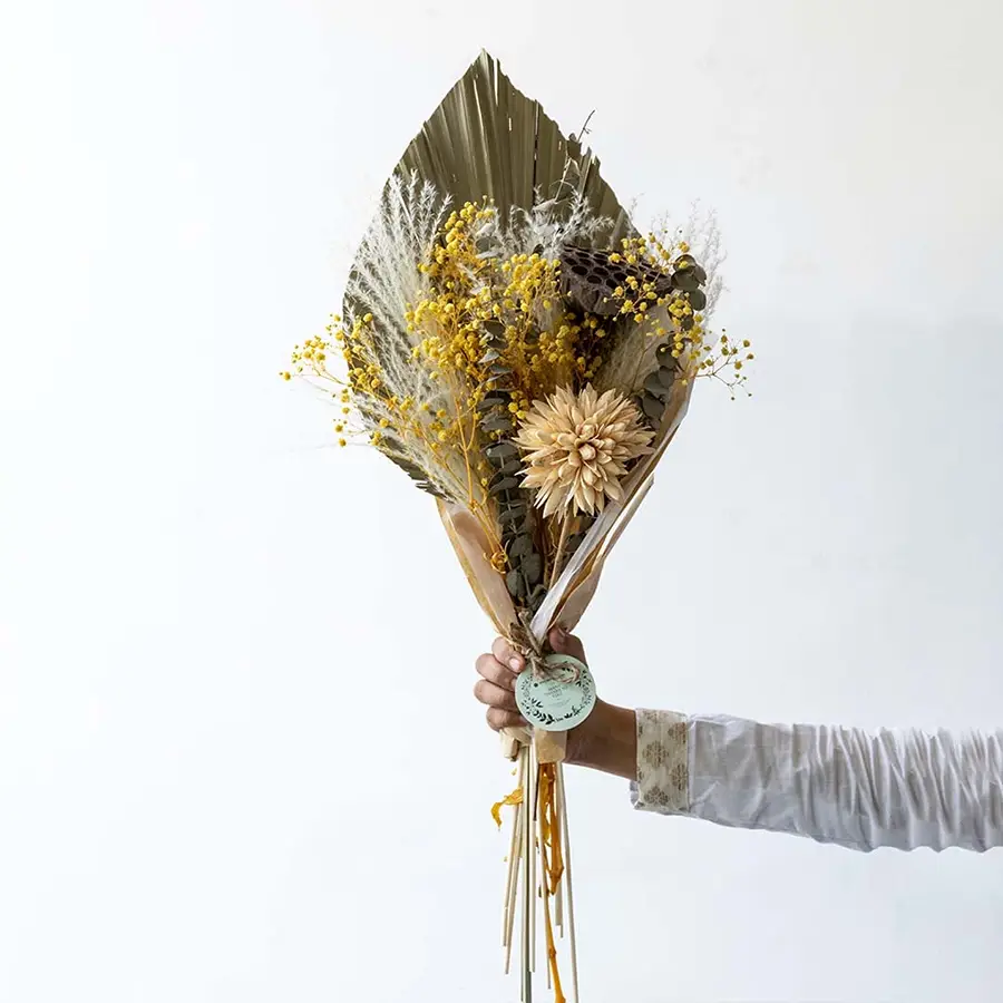 Vibrant yellow mixed dried flower bouquet on white background displaying bold color preserved texture and cheerful home decor styling.