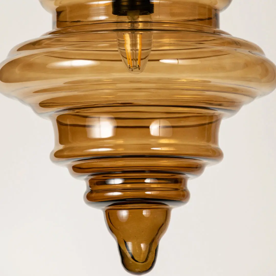 Amber ribbed glass pendant light showcasing textured layered glass craftsmanship and contemporary decorative lighting.