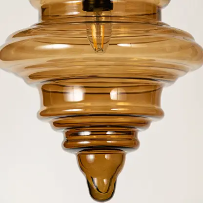 Amber ribbed glass pendant light showcasing textured layered glass craftsmanship and contemporary decorative lighting.