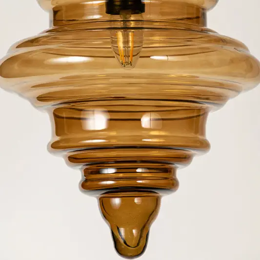 Amber ribbed glass pendant light showcasing textured layered glass craftsmanship and contemporary decorative lighting.