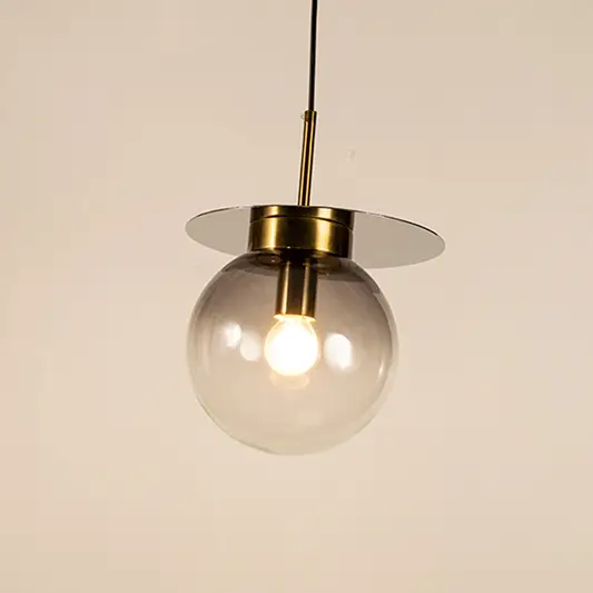 Clear and blue glass globe pendant light with brass accents and decorative disc detail for elegant ceiling lighting decor.