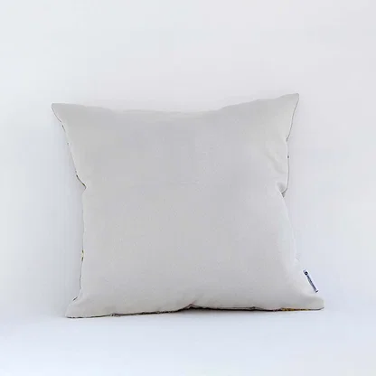 Side view of the floral cushion displaying its plush filled form and elegant embroidered pattern.