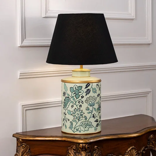 Table lamp on white background showcasing teal floral patterned ceramic base combined with an elegant black fabric lampshade.