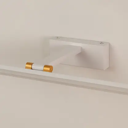 Closeup of white and gold metal picture light showing slim bar design smooth finish and warm directional illumination.