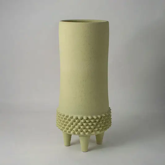 Light green ceramic vase with smooth finish and decorative patterned base placed on white surface against neutral background enhancing modern minimal home decor appeal.