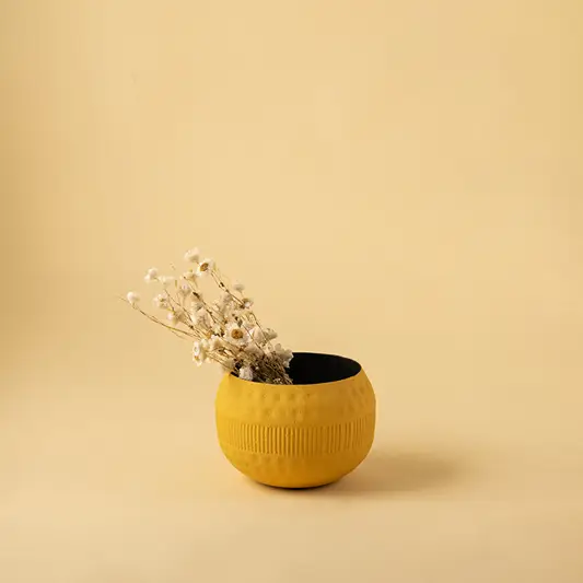 Single textured yellow metal bowl with dried stems for bright modern home decor and minimalist tabletop accents.
