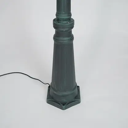 Closeup of black outdoor street lamp pole with ornate metal detailing for luxury exterior decor use.