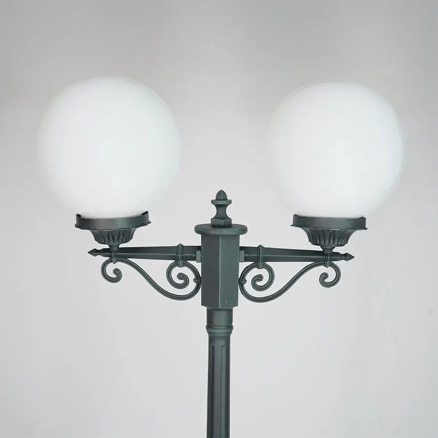 Closeup of vintage outdoor street lamp with dual frosted globe lights for elegant exterior decor styling.