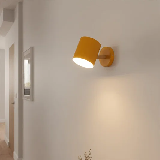 Modern white and brass spotlight wall light creating cozy hallway ambiance with warm interior lighting.