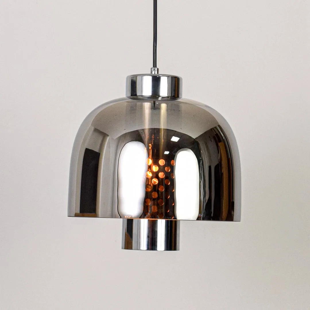 Smoke glass and chrome metal pendant light designed for modern dining room and home decor spaces.