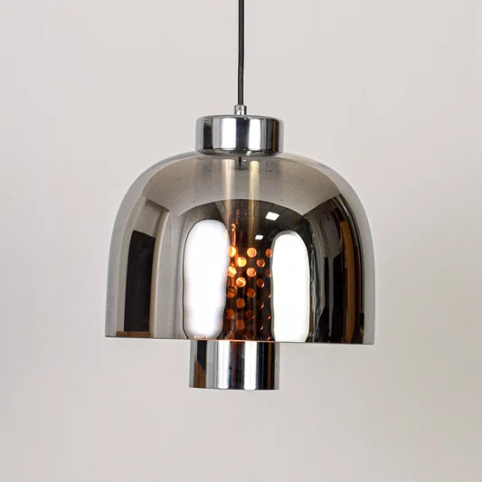 Smoke glass and chrome metal pendant light designed for modern dining room and home decor spaces.