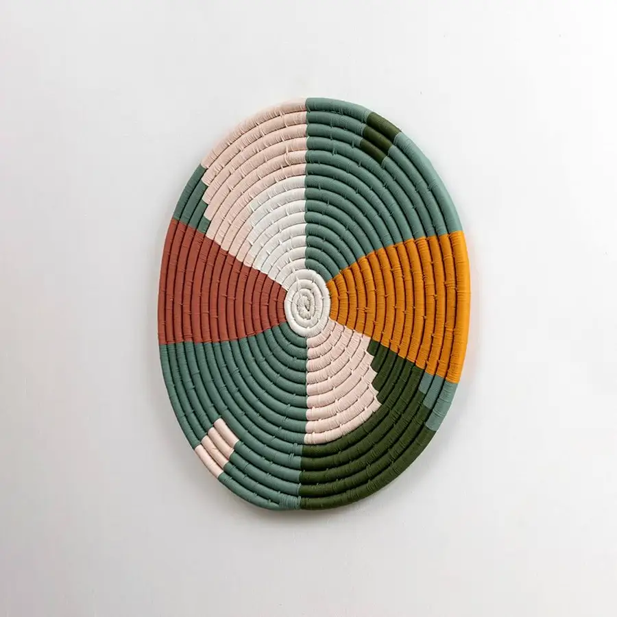 Closeup of handcrafted multicolor seagrass wall basket with geometric woven pattern for modern boho home décor.