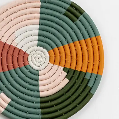 Closeup of woven multicolor seagrass wall basket with geometric pattern for stylish boho home wall décor display.