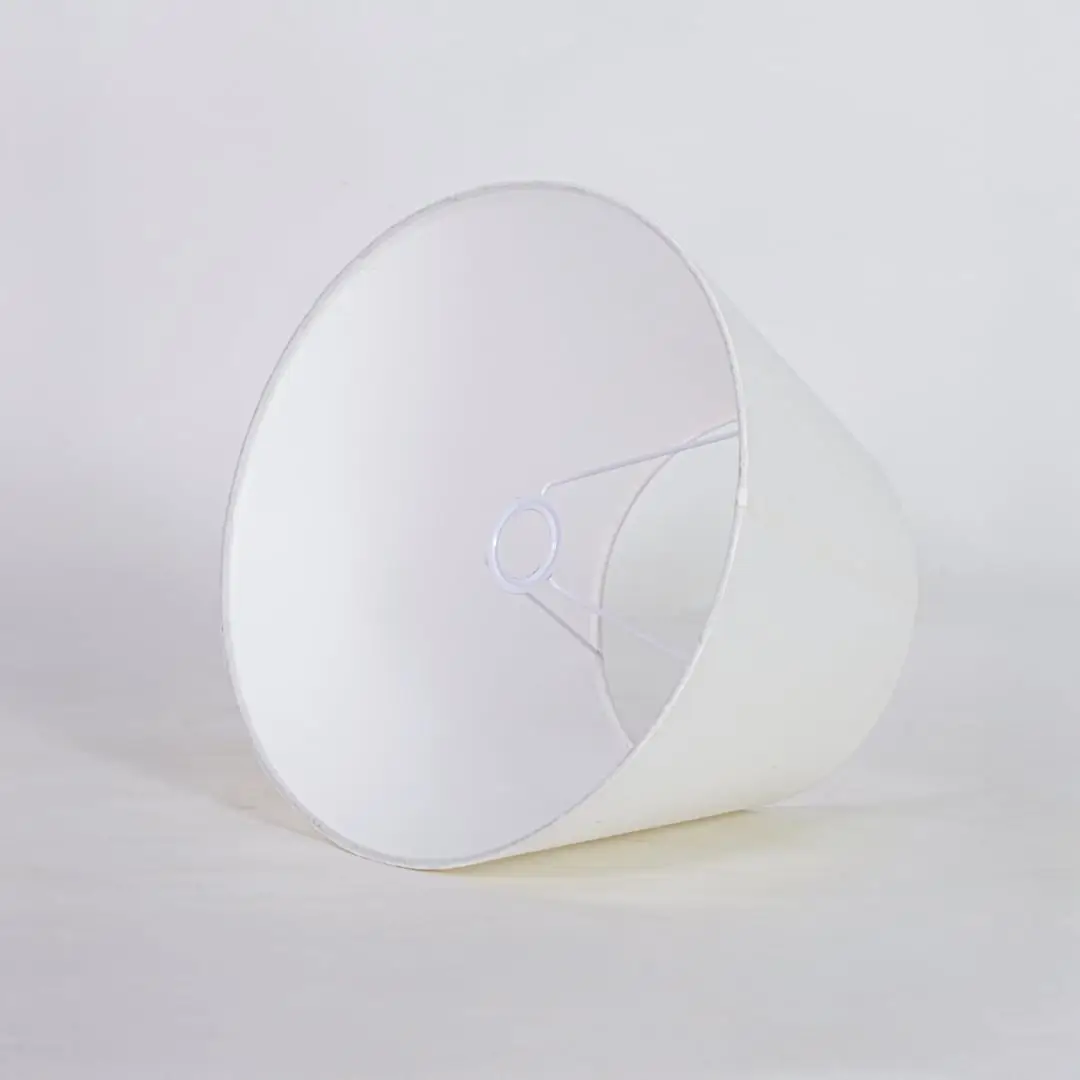 White tapered fabric lamp shade for modern table lamp styling and elegant interior lighting decor placement.