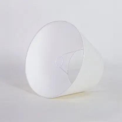 White tapered fabric lamp shade for modern table lamp styling and elegant interior lighting decor placement.