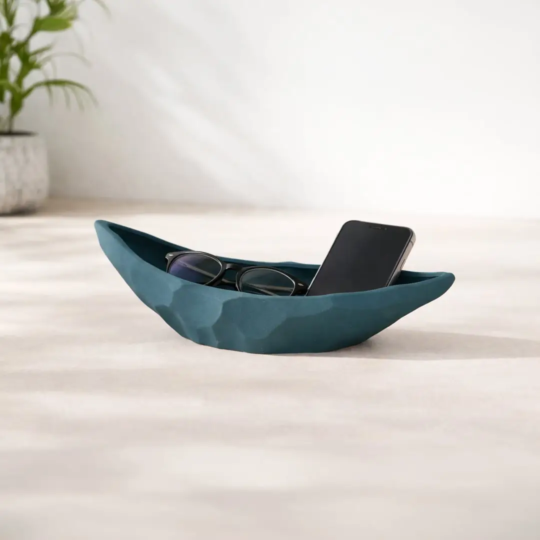 Teal ceramic decorative platter styled on coffee table holding accessories for contemporary home decor setting.