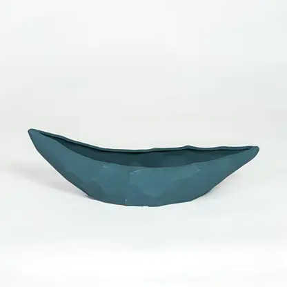 Teal ceramic decorative platter with sculpted curved design isolated on white background for contemporary table decor.
