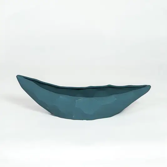 Teal ceramic decorative platter with sculpted curved design isolated on white background for contemporary table decor.