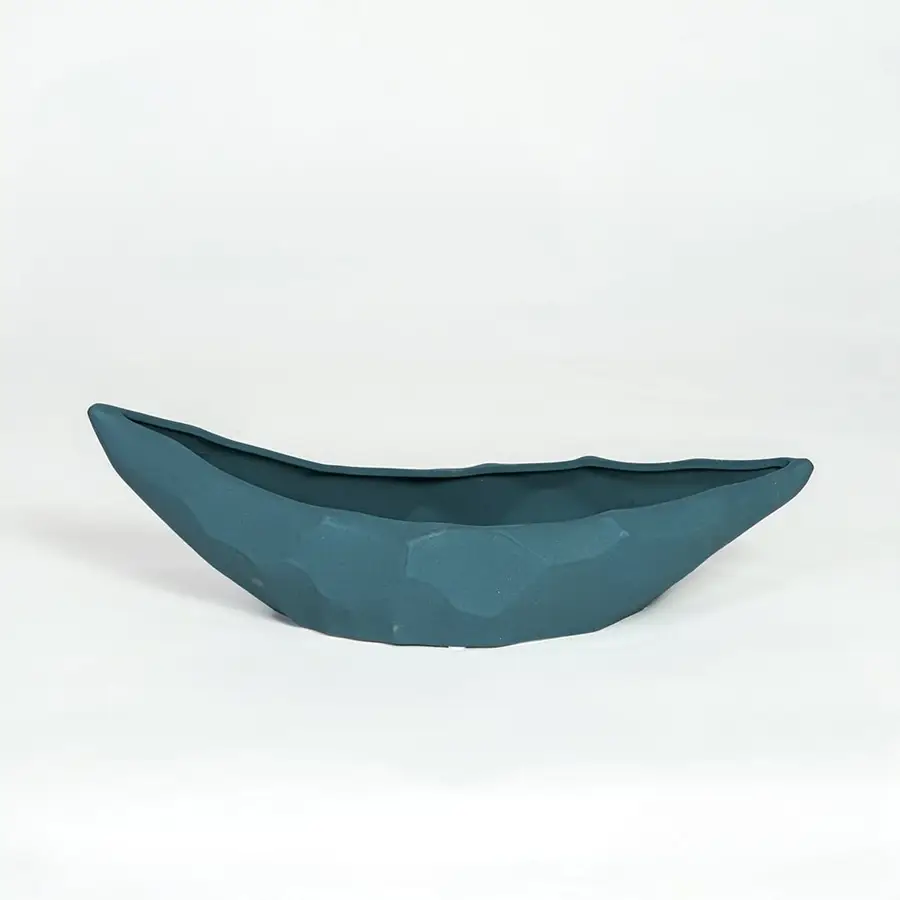 Teal ceramic decorative platter with sculpted curved design isolated on white background for contemporary table decor.