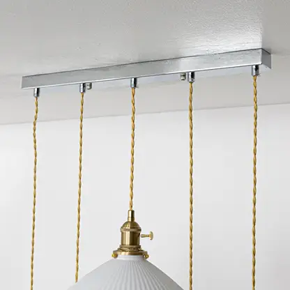 Silver metal linear ceiling canopy with decorative chains highlighting sleek modern craftsmanship.