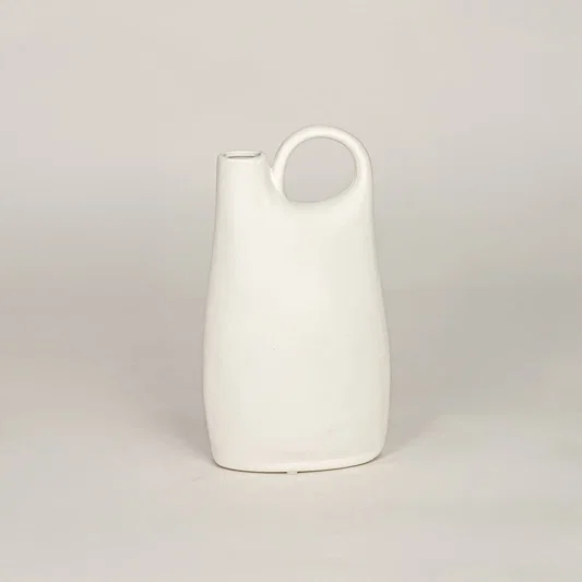 White ceramic decorative vase with sculpted handle design for modern tabletop shelf and console decor placement.