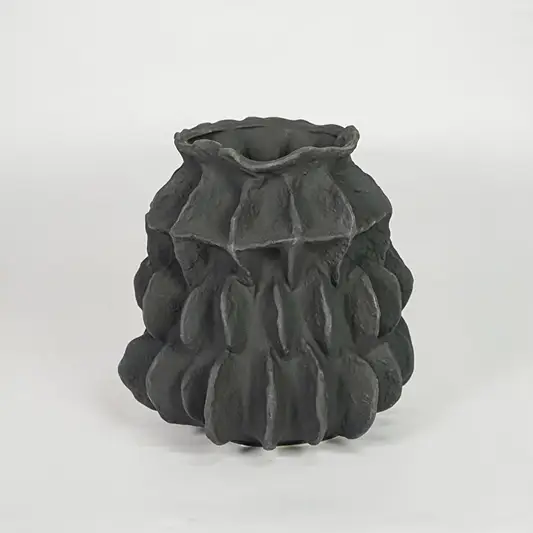 Closeup of dark grey ceramic vase with detailed sculpted texture for luxury tabletop and shelf decor home styling ideas.