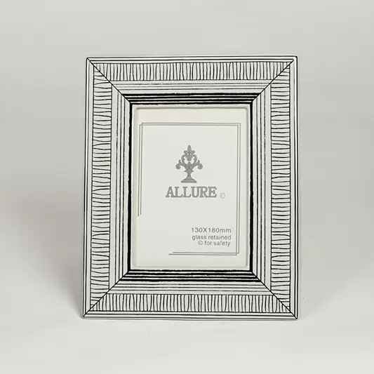 Silver metal photo frame with detailed patterned border isolated on clean white background for elegant tabletop display.