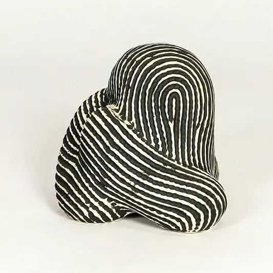 Abstract striped ceramic decor piece on white background modern artistic tabletop accent for living room office or entryway decor.