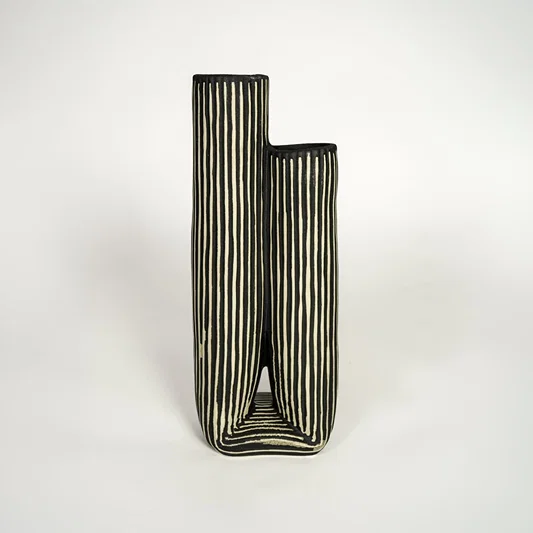 Modern black ceramic dual opening vase with striped texture ideal for console styling and home decor display.