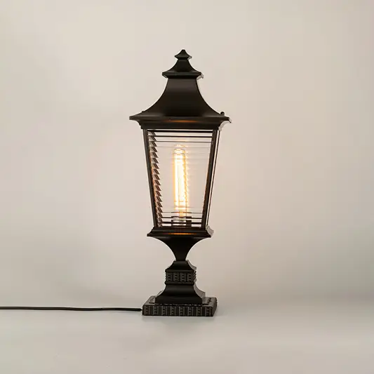 Vintage black outdoor gate light with glowing bulb for elegant exterior decor styling use.