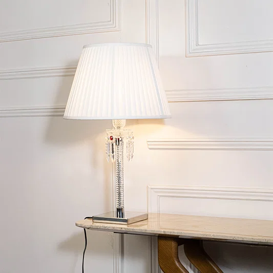 Classic table lamp in white finish with fabric shade for bedside or living room ambient lighting decor placement white background.