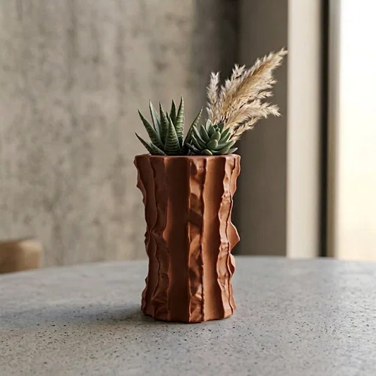 Terracotta ceramic flower vase with sculpted texture styled with dried blooms for modern home decor placement.