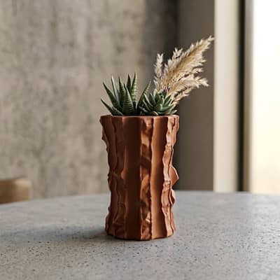 Terracotta ceramic flower vase with sculpted texture styled with dried blooms for modern home decor placement.